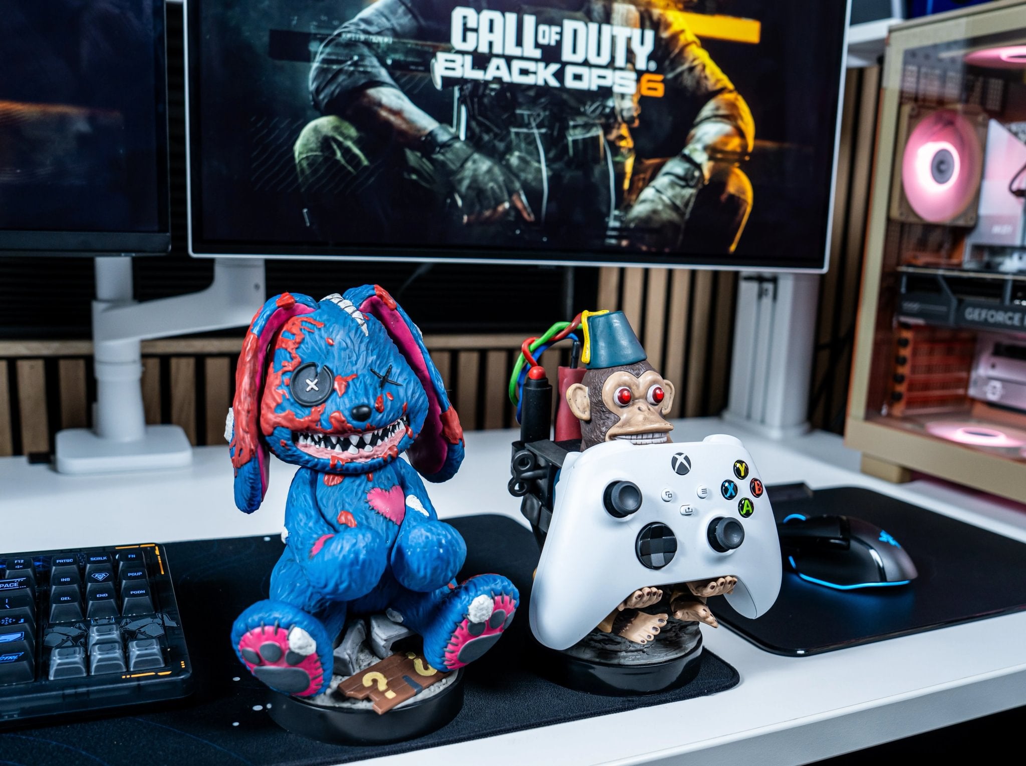 Call of Duty–themed Cable Guys controller holders featuring a blue rabbit and monkey on a gaming desk setup